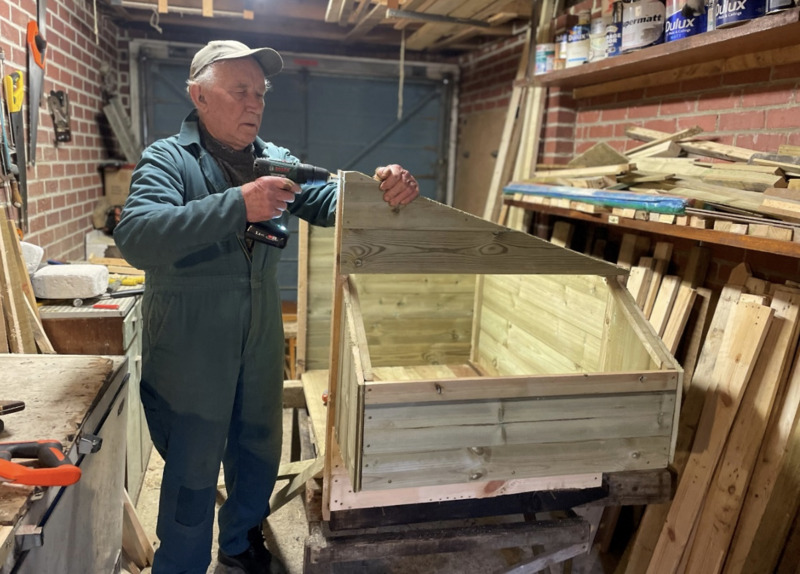 Alan Bright constructs a chicken coop.